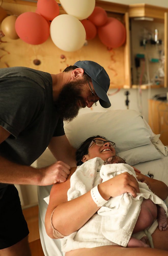 A father cradling his newborn baby