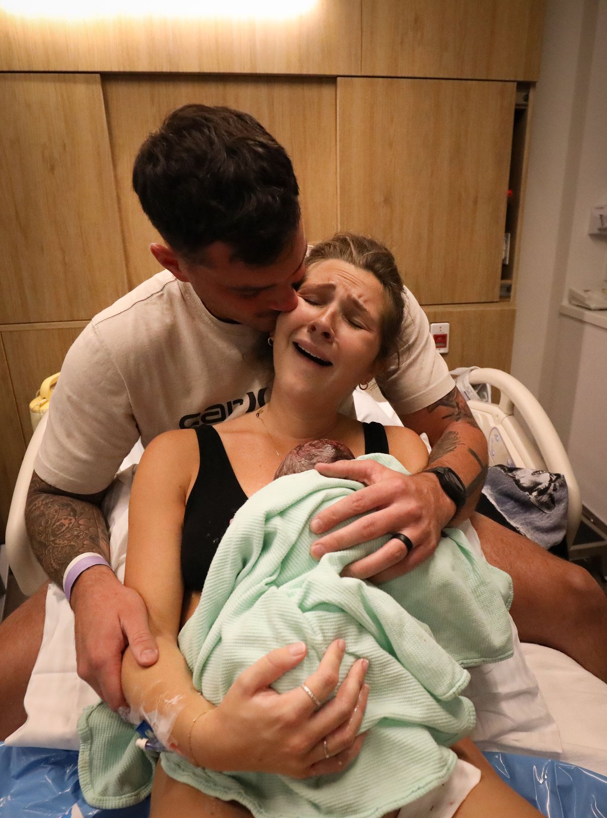 New parents holding their newborn moments after birth