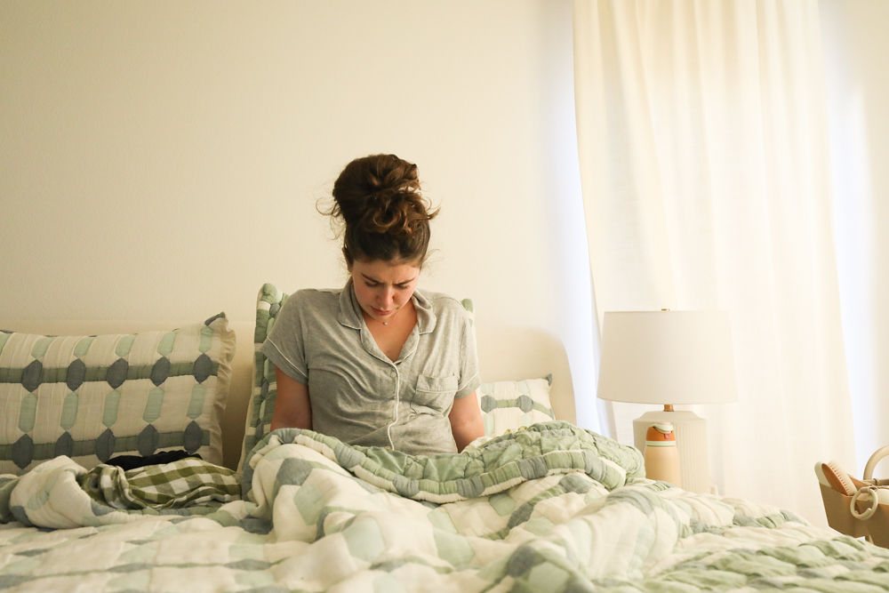 A mother holding her newborn close in soft morning light