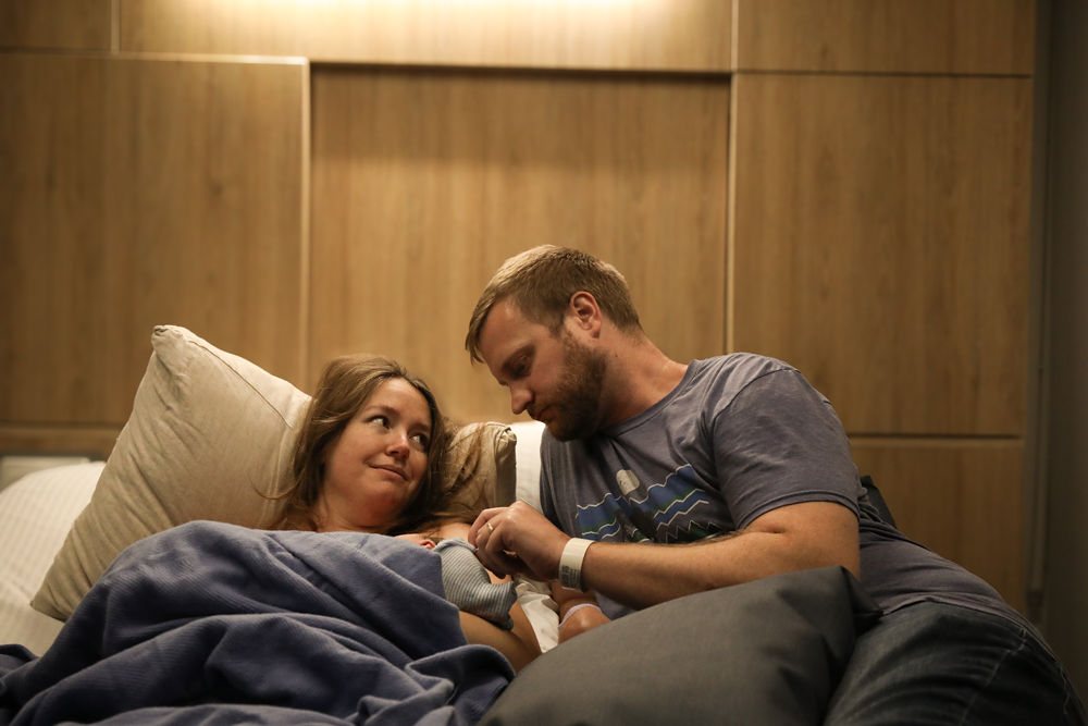 New parents resting with their newborn baby